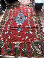 Full view of flat-woven rug showing red ground and geometric design