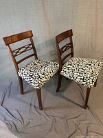 Pair of wooden Georgian dining chairs with curved top rails, crossbar back design, and upholstered floral seats.