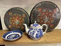 Two Wonder Bread fruit cake tins along with a Sadler teapot and Johnson Bros Willow pattern bowl displayed on a wooden surface.