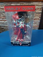 Front view of Harley Quinn bobble head figure inside original display box showing character and hammer accessory clearly.
