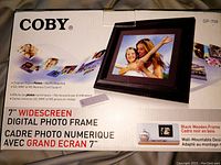 Photo of Coby DP-758 digital photo frame box showing model, features, and specifications