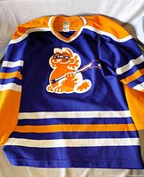 Front of Garfield hockey jersey showing character printing and striped blue, orange, white design
