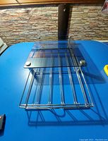 Top view of the metal and glass K Cup holder showing the parallel metal slots under the glass panel.