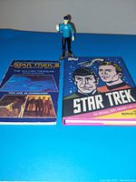 Spock figure standing with two collector books: Star Trek III collector book and Topps trading card book