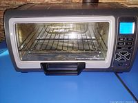 Front view of Hamilton Beach toaster oven showing glass door and metal rack inside