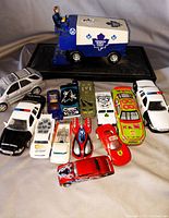 Front wide view of the 12 toy cars including Toronto Maple Leafs ice resurfacer and various police and race cars