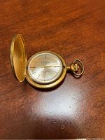 Front view of the open vintage pocket watch showing the silver dial with gold-tone hands, markers, and Dufonte Lucien Picard branding.