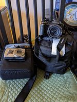 Kodak Easy Share M580 and Fujifilm FinePix S4000A cameras displayed with black carrying cases on a green quilted surface