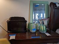 Group view of dark wooden jewelry box, 4 seafoam green candle holders, floral fairy lamp, and seafoam green framed beveled edge mirror