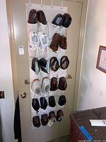 View of all shoes organized in fabric hanging shoe rack mounted over door with 20 pockets