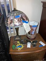 Photo showing the Monarchs of the Canyon stained glass table lamp and stained glass decorative items arranged on a wooden table.