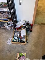 Top view of basket with assorted tools and hardware, flashlight, and packaging material