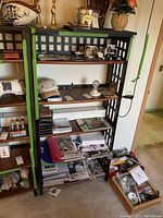 Overview of shelving unit displaying Yankees memorabilia including caps, books, VHS tapes, and smaller collectibles.