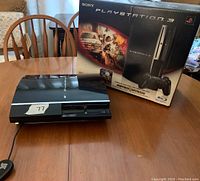 Sony PS3 console and original MotorStorm box on wooden table