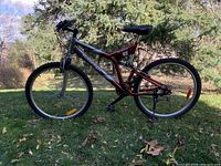 Side view of the whole mountain bike showing its silver and red frame with Raleigh branding.