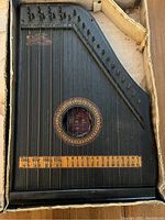 Top view of Wesenhaar guitar zither showing strings, tuning pegs, sound hole with decorative rosette and label.