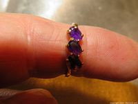 Photo of the ring on finger showing the three amethyst stones.