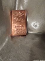 Photo of single copper bar showing front face with date and purity markings
