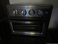 Front view of the Cuisinart 7-in-1 Air Fryer Convection Toaster Oven showing four control knobs and glass door.