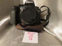 Front view of Canon EOS 60D camera body with lens cap on and camera strap visible.