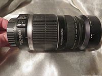 Side view of Canon EF-S 55-250mm zoom lens showing zoom ring, focus ring, image stabilizer label, and lens mount end with 58mm filter size mark.