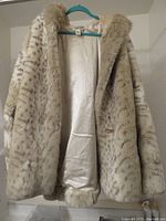 Front view of Coldwater Creek oversized faux fur parka jacket showing interior ivory lining and soft spotted animal print faux fur.