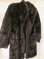 Fur coat hanging, showing texture and color of the dark brown bark fur exterior.