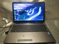 Laptop powered on showing operating system desktop screen with road wallpaper.