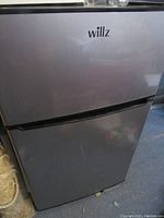 Front view of the Willz mini refrigerator showing stainless steel surface and two doors.