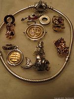 Photo showing Pandora Moments silver bracelet with butterfly clasp and 8 individual charms in silver and gold tones with some red details, all new and never worn.