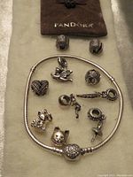 Complete set of Pandora Moments silver bracelet with assorted charms and pouch