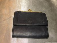 Front view of black leather Princess Gardner wallet with embossed logo