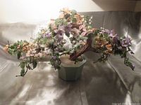 Front view of the large vintage Chinese bonsai flower tree showcasing multi-colored jade, quartz, stone, and glass flowers arranged on three main branches above a celadon green ceramic pot and wooden base.