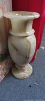 Clear front view of a vintage carved marbled onyx vase showing its polished cream and brown veining with flared lip and rounded body.