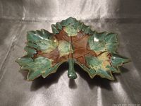 Top view of the maple leaf shaped pottery dish showing brown and green glaze and leaf details.
