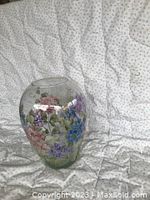 Front angled view of the rounded glass vase showing the hand painted floral design on the lower and mid portions.