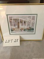 Framed print by Joyce Kamikura showing a house porch with flowers, with Lot 28 card in the photo.
