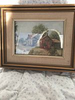 Framed print showing a rural homestead scene including a red barn, house, trees, signed by Kierstead, in gold-tone frame and beige matting.