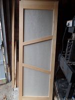 Full view of one maple door with linen-look insert panel, showing wood braces and overall condition.