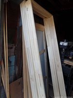 Photo showing two vertically standing pine door frames measuring about 25.5" wide by 81.5" high, made from light pine wood.