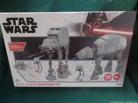 Front view of the sealed box showing the Star Wars logo, images of the AT-AT, AT-ST, and Snowspeeder models, total 499 pieces, suitable for ages 8+. Colorful graphics with Darth Vader and Star Wars ships in background.