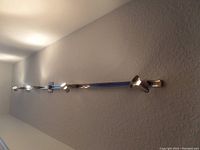 Full view of chrome track light mounted on a ceiling, approx 8 feet long showing five spotlight heads.