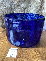 Side view of cobalt blue blown glass bowl showing thick glass and mottled pattern.