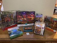 Wide shot of all puzzles and card game in their boxes arranged on a wooden table.