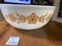 Side view showing gold floral pattern on white Pyrex bowl