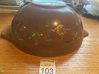 Photo of the outside of the brown mixing bowl showing the faded Cinderella B pattern design and some discoloration.