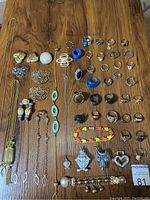 Full view of all jewelry items spread on table including rings, bracelets, shoe clips, and necklaces.