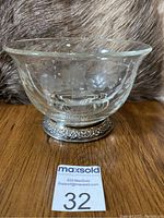 Side view of glass bowl showing etched floral pattern and sterling silver foot with detailed embossing.