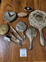 Overview of all vanity accessories including handheld mirrors, decorative boxes and brushes arranged on wooden surface