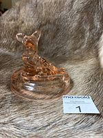 Pink Jeanette glass Scottie dog vanity powder dish lid shown from the side on a textured surface.